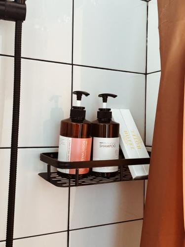 a shelf in a bathroom with two products on it at Unit Hotel in Almaty