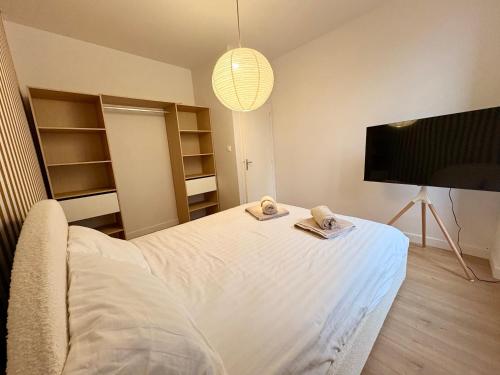 a bedroom with a bed with two towels on it at Charmant T2 hyper-centre, proche gare & mer in Saint-Brieuc