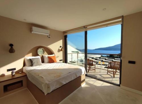 a bedroom with a bed and a balcony with a view at Villa Ship Ahoy in Kaş