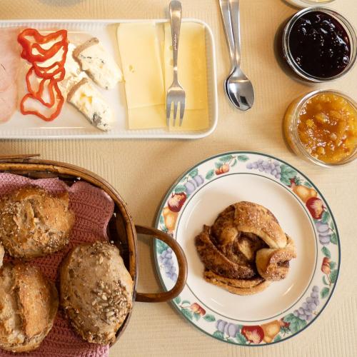 a table with a plate of pastries and a basket of food at Sommerliv Bed and Breakfast in Tranekær