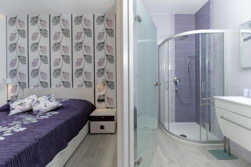 a bathroom with a bed and a glass shower at Villa Luce in Labin