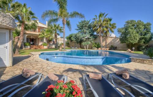 a swimming pool in a yard with palm trees at Can Gual in Inca