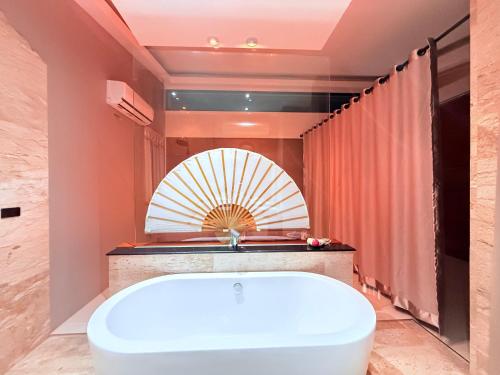 a bath tub in a bathroom with a large mirror at Koh Chang Pool Villa Viewthalay in Ko Chang