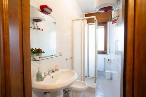 a white bathroom with a sink and a toilet at Casa Wanda LAWANDA in Oristano