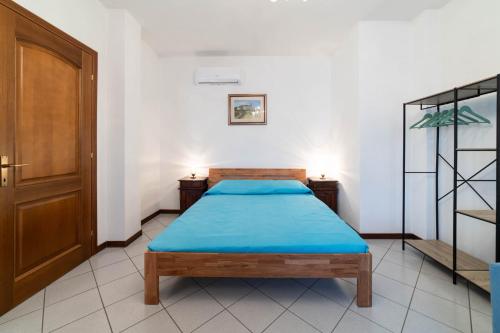 a bedroom with a bed with a blue blanket on it at Casa Wanda LAWANDA in Oristano