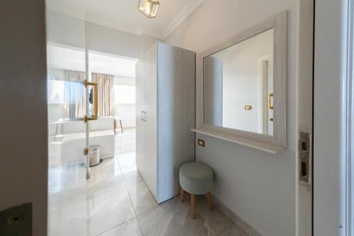 a white bathroom with a mirror and a chair at Sunshine Pyramids& Grand Museum View in Cairo
