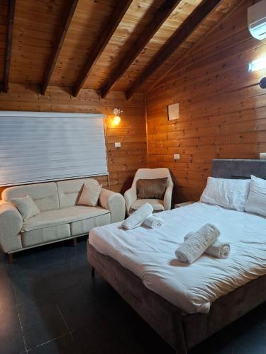 a bedroom with a large bed and a couch at צימרים מול הנוף in Yarka
