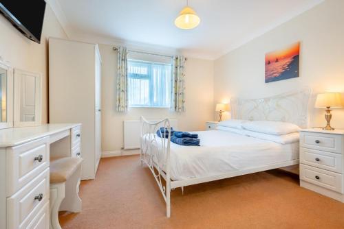 a white bedroom with a bed and a desk at 3 Bed in St. Merryn oc-r30137 in Saint Merryn