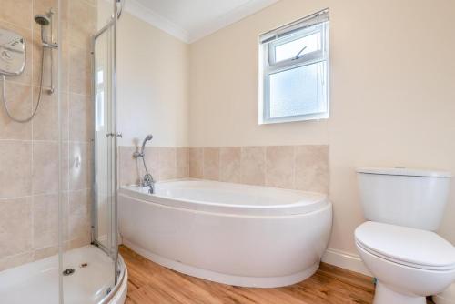 a bathroom with a white tub and a toilet at 3 Bed in St. Merryn oc-r30137 in Saint Merryn