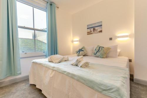 a bedroom with a white bed with two dolls on it at 2 Bed in St. Ives oc-s28155 in St Ives
