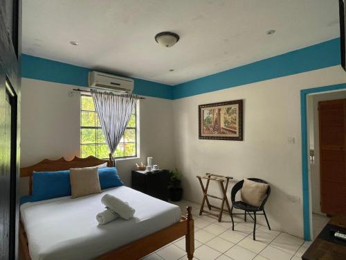 sypialnia z łóżkiem, niebieskimi ścianami i oknem w obiekcie Golden Hideaway Inn w mieście Gros Islet