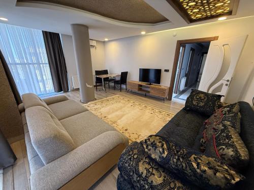 a living room with a couch and a tv and a table at Beyaz Suites in Midyat