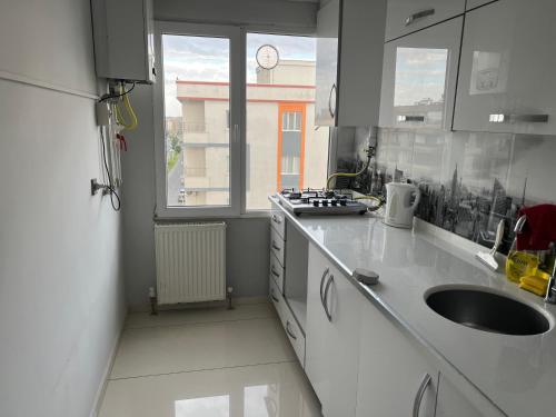 a white kitchen with a sink and a window at Beyaz Suites in Midyat