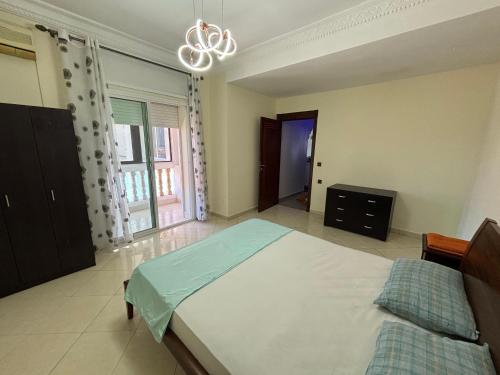 a bedroom with a large bed and a chandelier at Casandalus in Larache