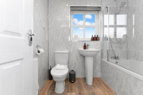 a bathroom with a toilet and a sink and a shower at Buie's Runway Retreat in EDI
