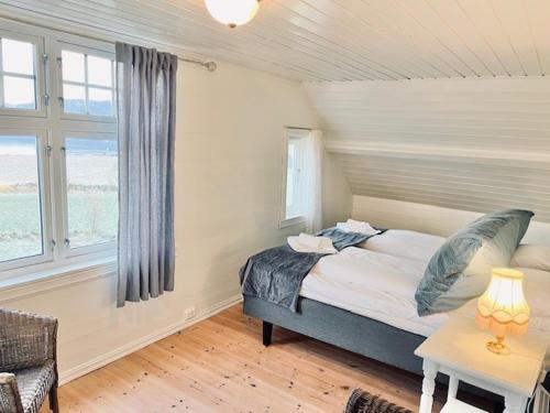 a bedroom with a bed and a table and a window at Oanes House in Forsand
