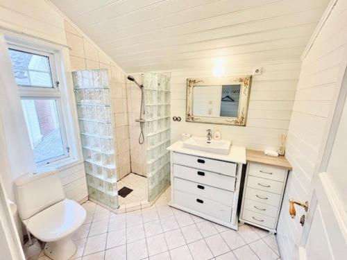 a bathroom with a sink and a shower and a toilet at Oanes House in Forsand