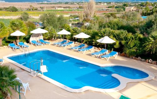 a pool at a resort with chairs and umbrellas at Finca Sa Pedrera in Can Picafort