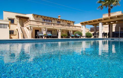 a large swimming pool in front of a house at Catalina in Alcudia