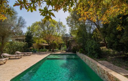 a swimming pool with turquoise water and trees at Can Pintad in Ruberts