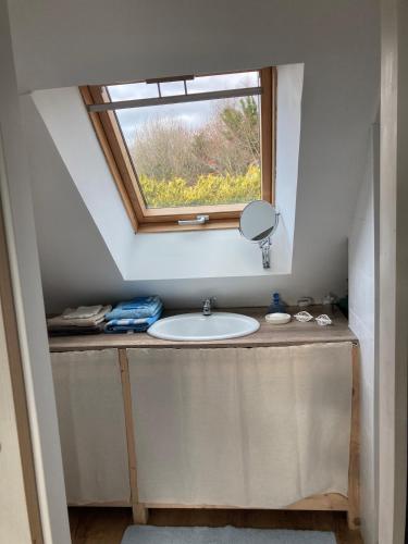 a bathroom with a sink and a window at Portec la mer et le sentier côtier à pied in Moëlan-sur-Mer
