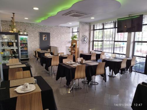 a restaurant with tables and chairs and a green ceiling at Alojamento Central I - Funchal in Funchal