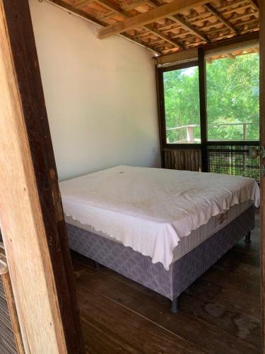 a bed in a room with two windows at Fazenda Shalom in Tucano
