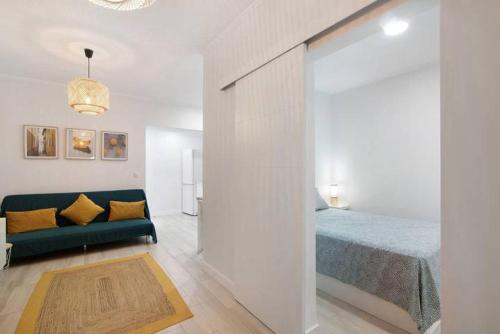 a living room with a bed and a green couch at Casa Belice in Vila Real de Santo António