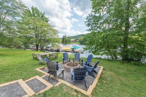 a group of chairs and a fire pit next to a lake at American Eagle Lodge by Railey Vacations in McHenry