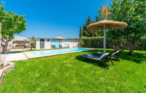 a yard with a pool and a umbrella and chairs at Es Collet De Manacor in Manacor