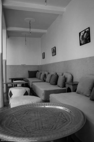 a living room with couches and a table at Maison d'hôtes Dar Farhana in Ouarzazate