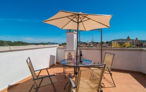 a table and chairs on a roof with an umbrella at Roser De Arta in Artá