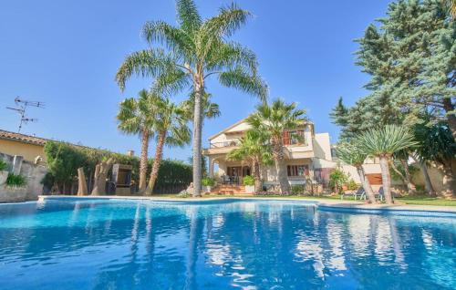 a large swimming pool in front of a house with palm trees at Can Gual in Inca