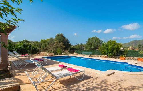a swimming pool with two lounge chairs and a swimming pool at Sa Plana Port Nou in Cala Millor