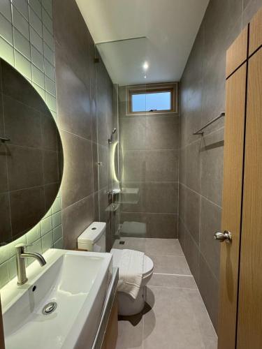 a bathroom with a toilet and a sink and a mirror at The Pool House Koh Lanta in Ko Lanta
