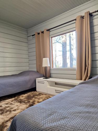 a bedroom with two beds and a window at Villa Irjala in Oulu