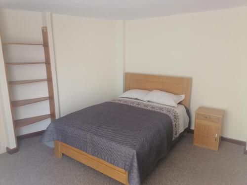 una piccola camera da letto con un letto e una libreria di Casa ENLACE a La Paz
