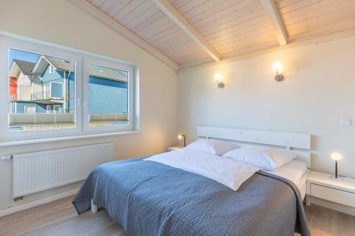 a bedroom with a large bed and a window at Ferienhaus Strandflieder in Dagebüll