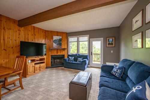 a living room with a blue couch and a tv at Après 18 by Railey Vacations in McHenry