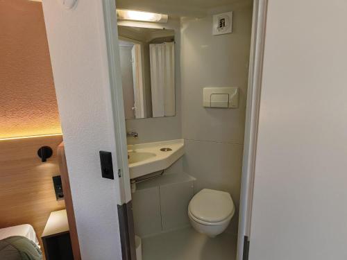 a small bathroom with a toilet and a sink at Premiere Classe Dunkerque Est Armbouts Cappel in Armbouts-Cappel