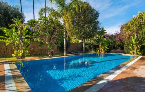 ein Swimmingpool in einer Villa mit Palmen in der Unterkunft Can Mandol in Inca