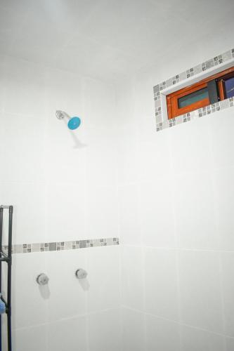 a white bathroom with a shower with a window at Ruby Grey Suite in Mineral de Angangueo