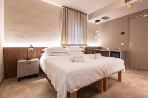 ein Schlafzimmer mit einem großen Bett, auf dem Handtücher liegen in der Unterkunft Aima Boutique Rooms in Costa Volpino