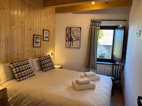 a bedroom with a bed with two towels on it at Cal Not Celler, Cerdanya in Escardacs
