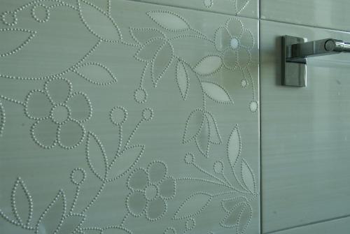 a shower door with a pattern on the wall at La Casa di Boz B&B in Nuoro
