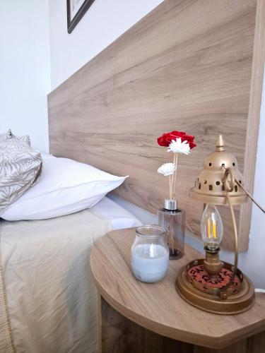 a bed with a wooden headboard and a table with a lamp at Monoambiente luminoso con Jacuzzi Relax y estilo in Córdoba