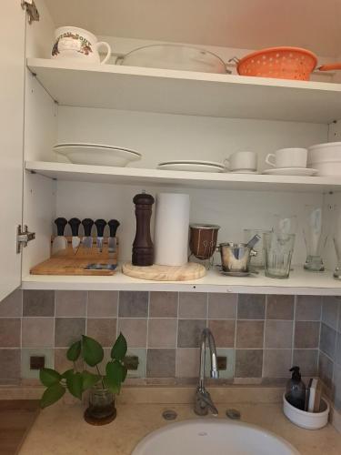a kitchen shelf with dishes and utensils on it at Monoambiente luminoso con Jacuzzi Relax y estilo in Córdoba