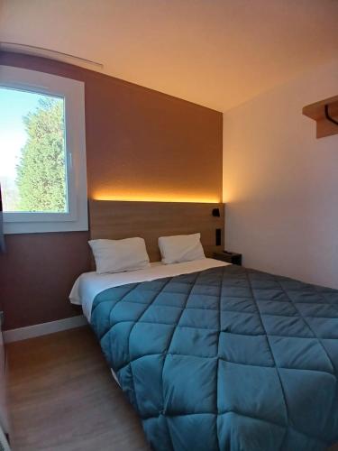 a bedroom with a large bed with a window at Premiere Classe Dunkerque Est Armbouts Cappel in Armbouts-Cappel