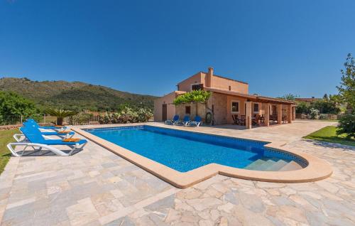a swimming pool with two chairs and a house at Can Cremat in Artá