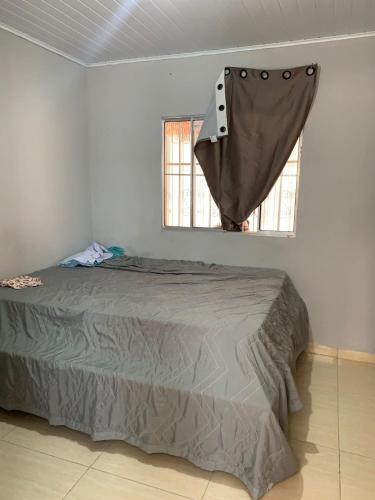 a bed in a room with a sheet hanging from a window at Edilson santos in João Pessoa